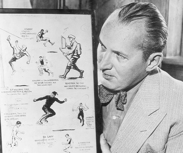 Robert Ripley holding Champs and Chumps cartoon