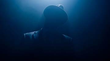 Silhouette of man in suit and hat