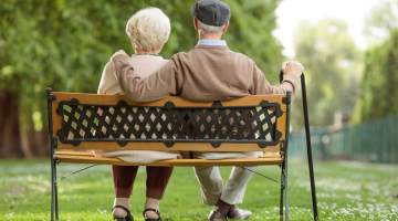 Elderly people sitting on bench.