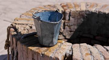 A water well with an old bucket