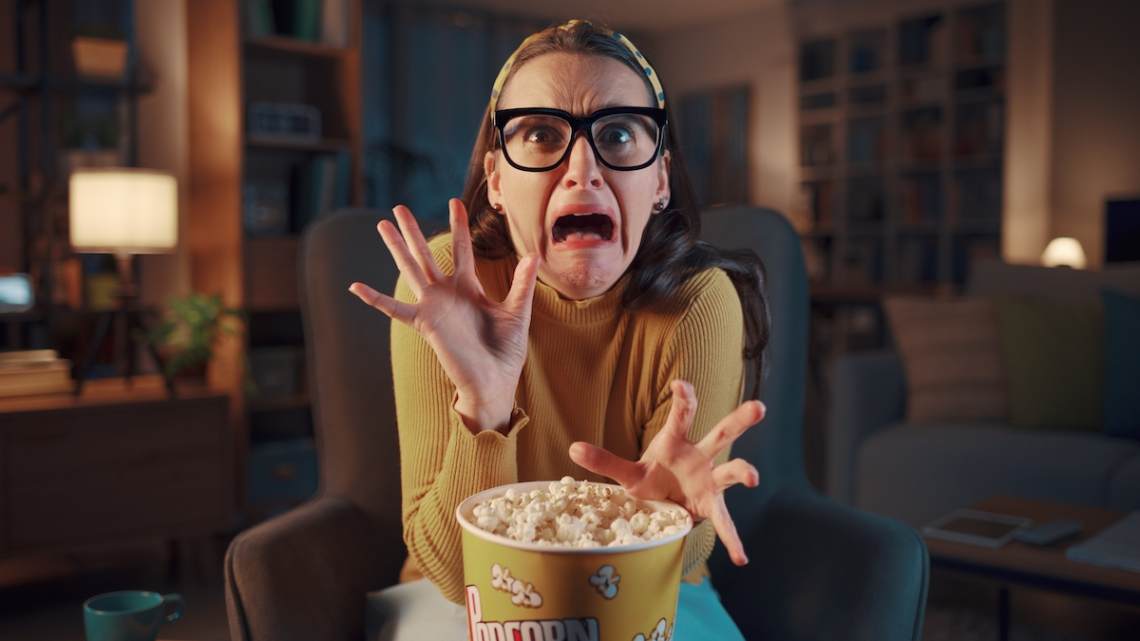 Scared woman watching a horror movie